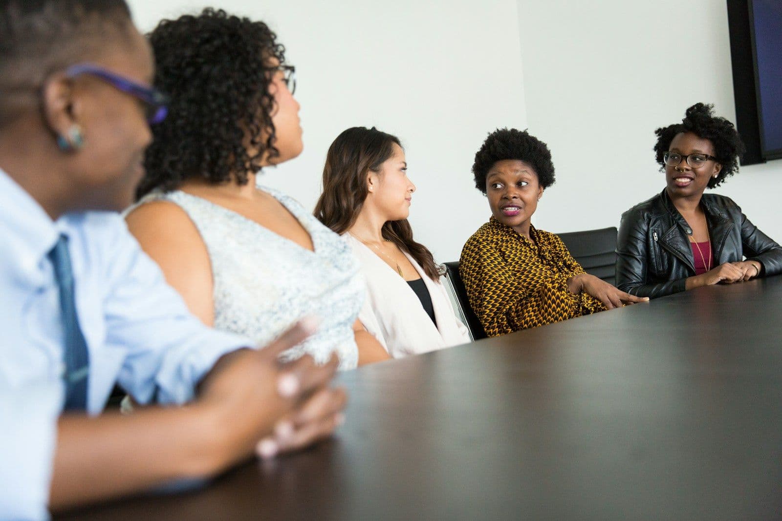 A diverse team listening during a boardroom meeting