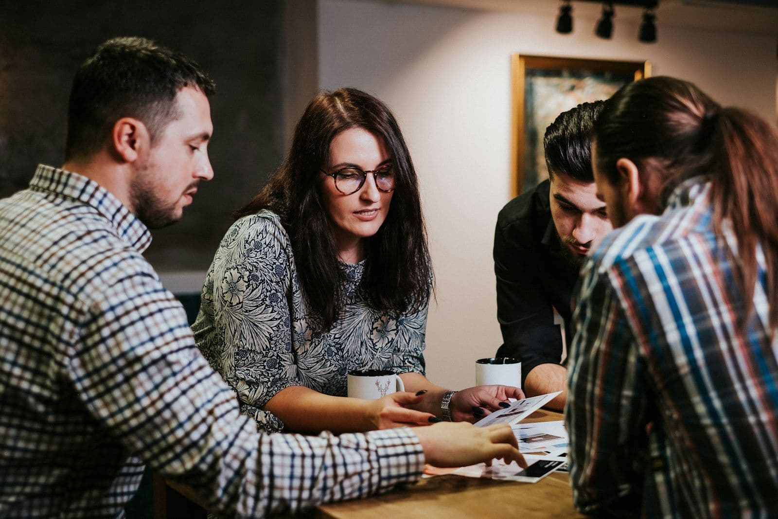 Four colleagues reviewing documents together at a wooden table